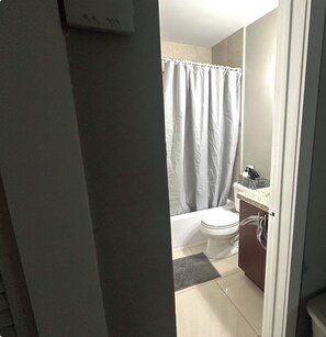 A bathroom with a toilet, a shower curtain, and a sink with a countertop. - 2 bedroom house , one bedroom
Available small dog on property plenty of parking (Hollywood)