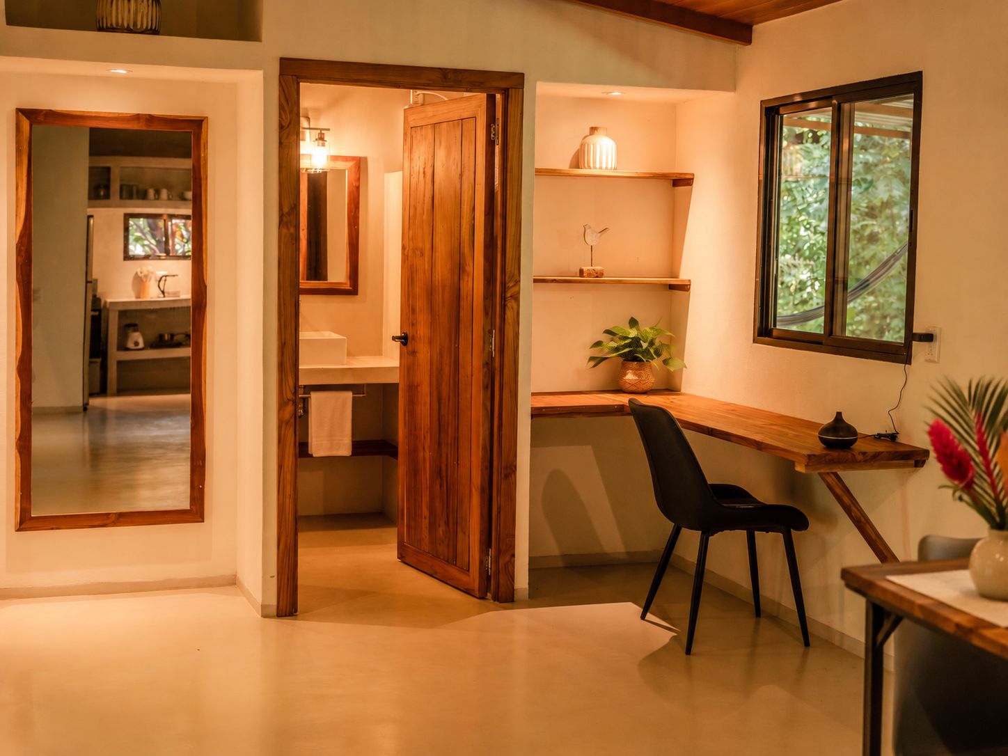 Una cocina moderna con armarios de madera, horno integrado y ventana con vistas a la vegetación.