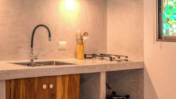A kitchen with a built-in sink, a gas stove, wooden cabinets, and a window with a view.