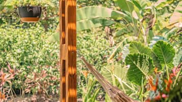 A wooden pergola with a hanging planter and a hammock.