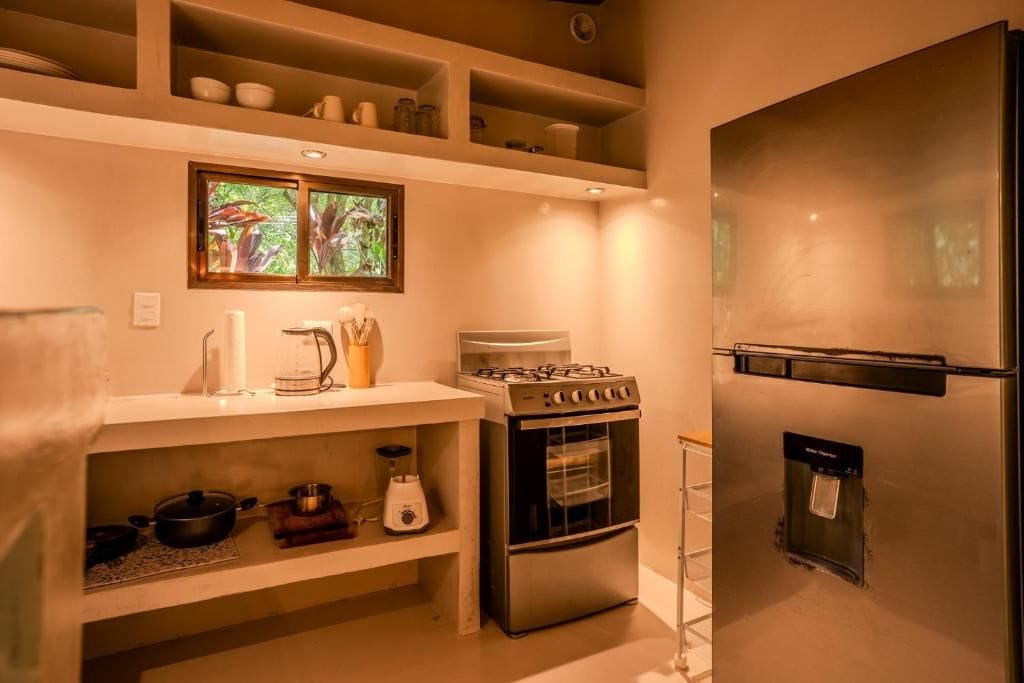 A compact kitchen with a gas stove, oven, and a refrigerator.