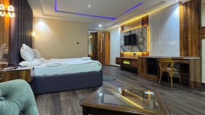 A modern bedroom with a bed, bedside table, and a glass-top coffee table. - Banky Hotel & Suites (Ado Ekiti)
