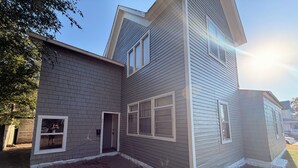 A two-story house with a brick foundation, a covered porch, and a garage. - Beautiful 2-bedroom apartment with AC in charming Hutchinson (Hutchinson)