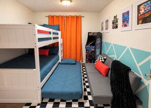 A room with bunk beds, a sofa, arcade games, and a checkered floor. - Near ASU • King Bed • Arcade • Pool/Spa • Sleeps 8 • Pets • 65" TV • W/D (Tempe)