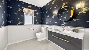 Ein Badezimmer mit Toilette, Waschbecken und Spiegel.