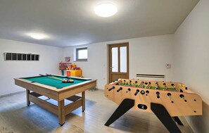 A room with a pool table and a foosball table, a window, and a door. - Villa Martin a family countryside & spa retreat (Snašići)