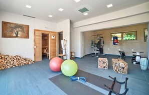 A gym with exercise equipment, a punching bag, and a yoga mat. - Villa Martin a family countryside & spa retreat (Snašići)