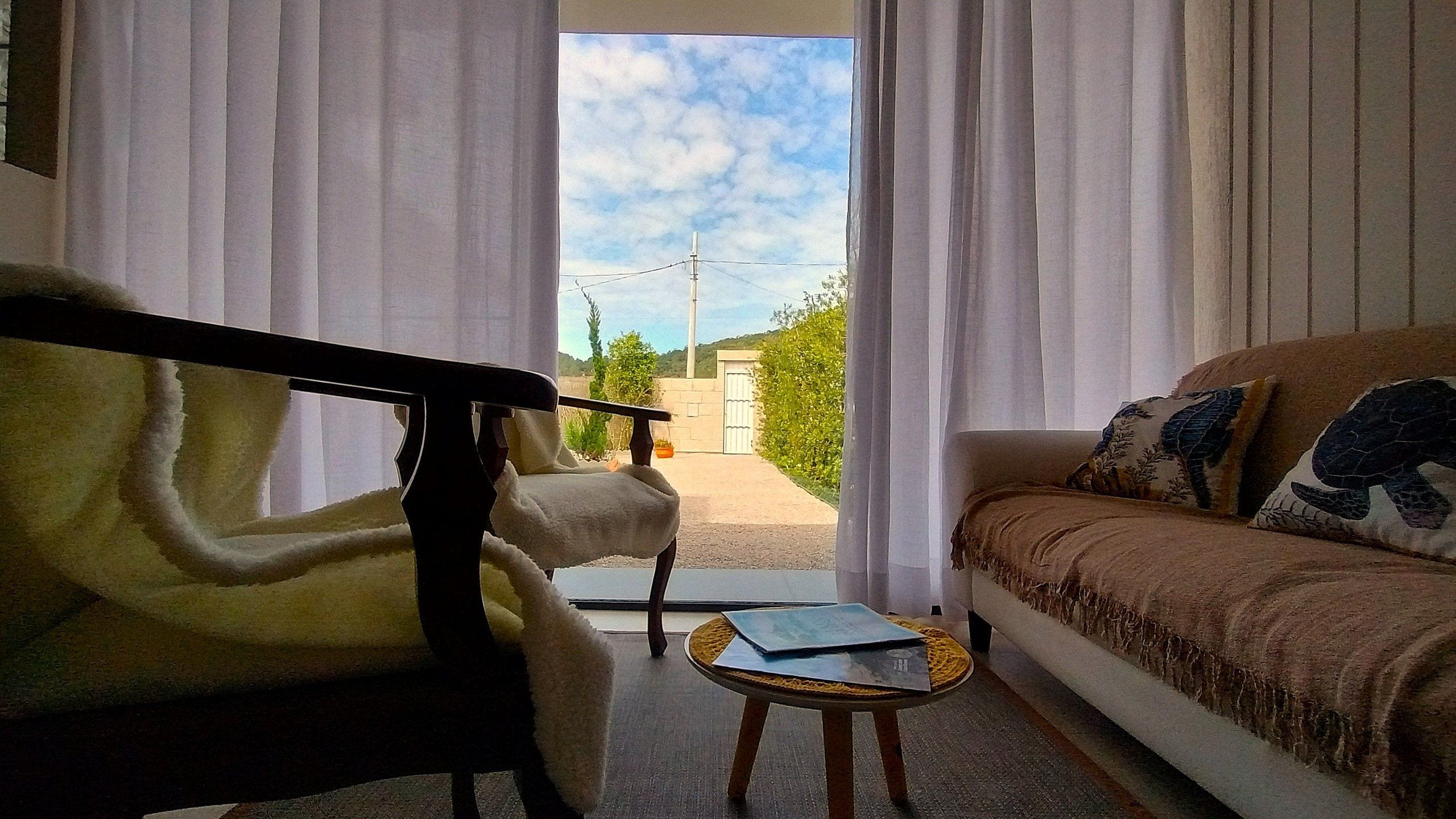 Ein Zimmer mit einer Couch, einem Sessel und einem kleinen Tisch.