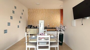 A compact dining area with a brick backsplash, a refrigerator, and a small kitchen counter.