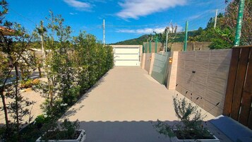 Un camino que lleva a una entrada con puerta y un cielo despejado.