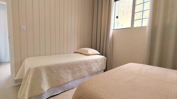 Una habitación con dos camas, una con colchón acolchado y la otra con un colchón sencillo.