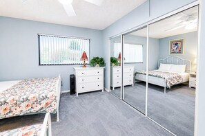 A bedroom with a bed, a dresser, a mirror, and a window with blinds. - Golden Sands 1617 (Ocean City)
