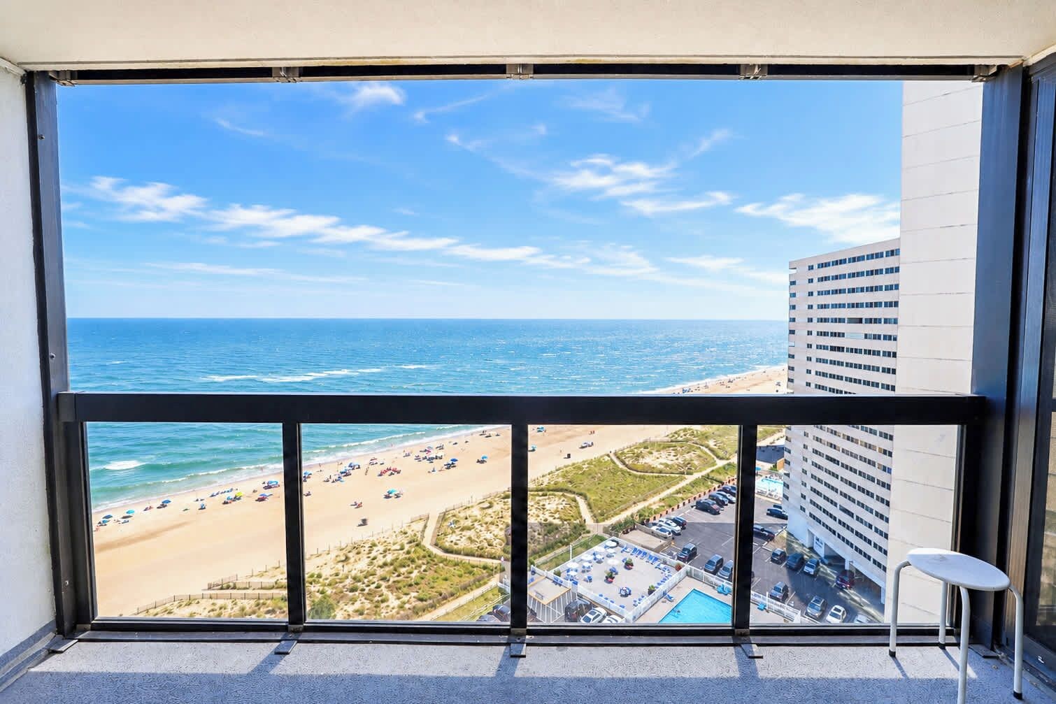 A balcony with a view of the beach and ocean.