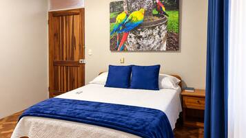 Ein Schlafzimmer mit einem Bett, einem Nachttisch, einer Holztür und einem Gemälde bunter Vögel.