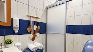 Ein Badezimmer mit Toilette, Waschbecken und Duschbereich.