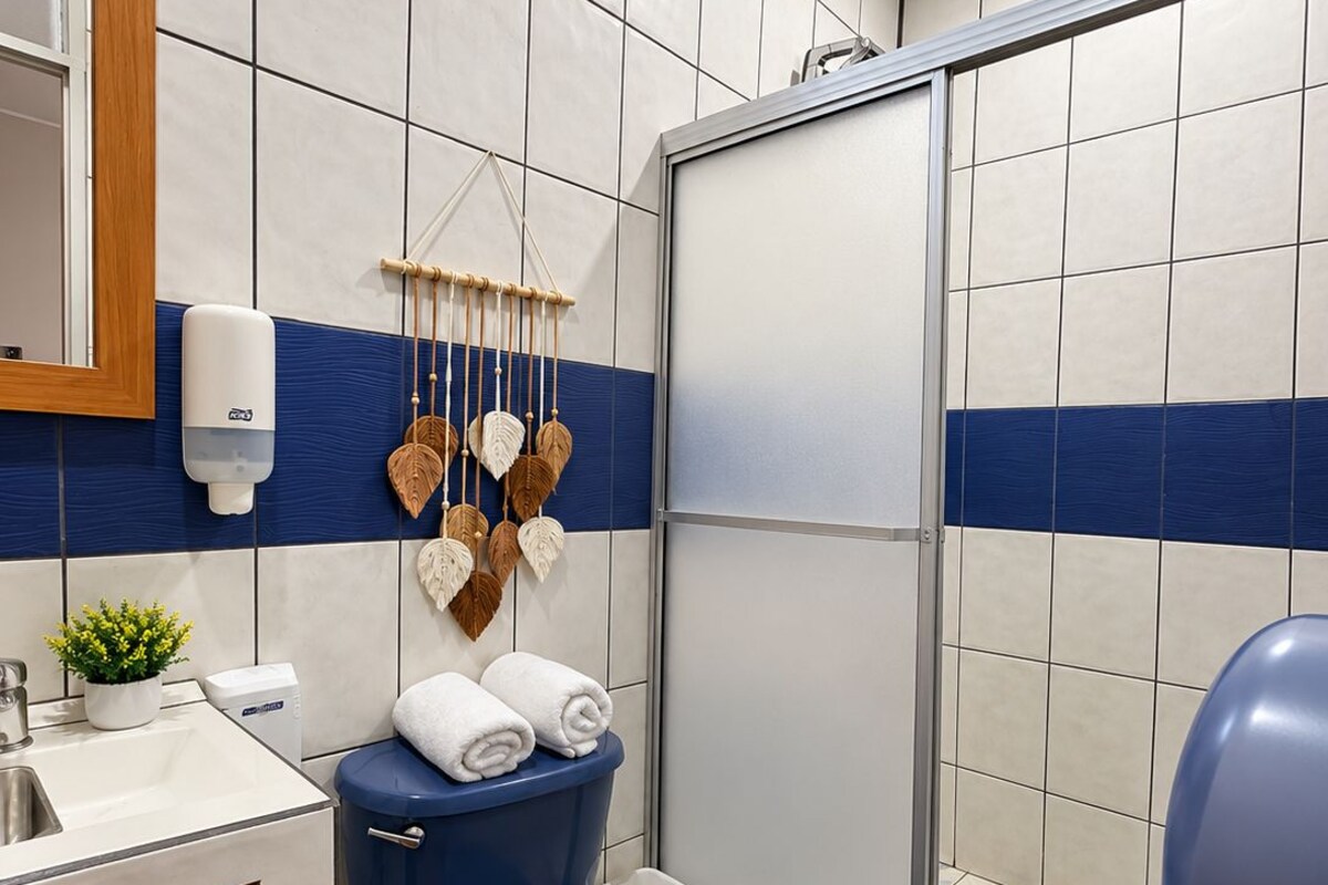 Een badkamer met toilet, wastafel en douchehoek.