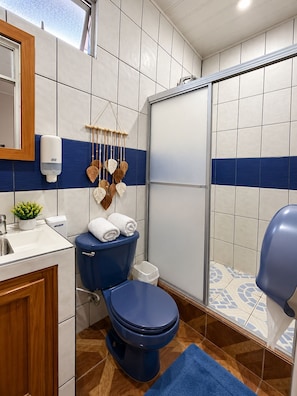 A bathroom with a toilet, sink, and shower area. - Hotel Sueño de Luna (Aguas Zarcas)