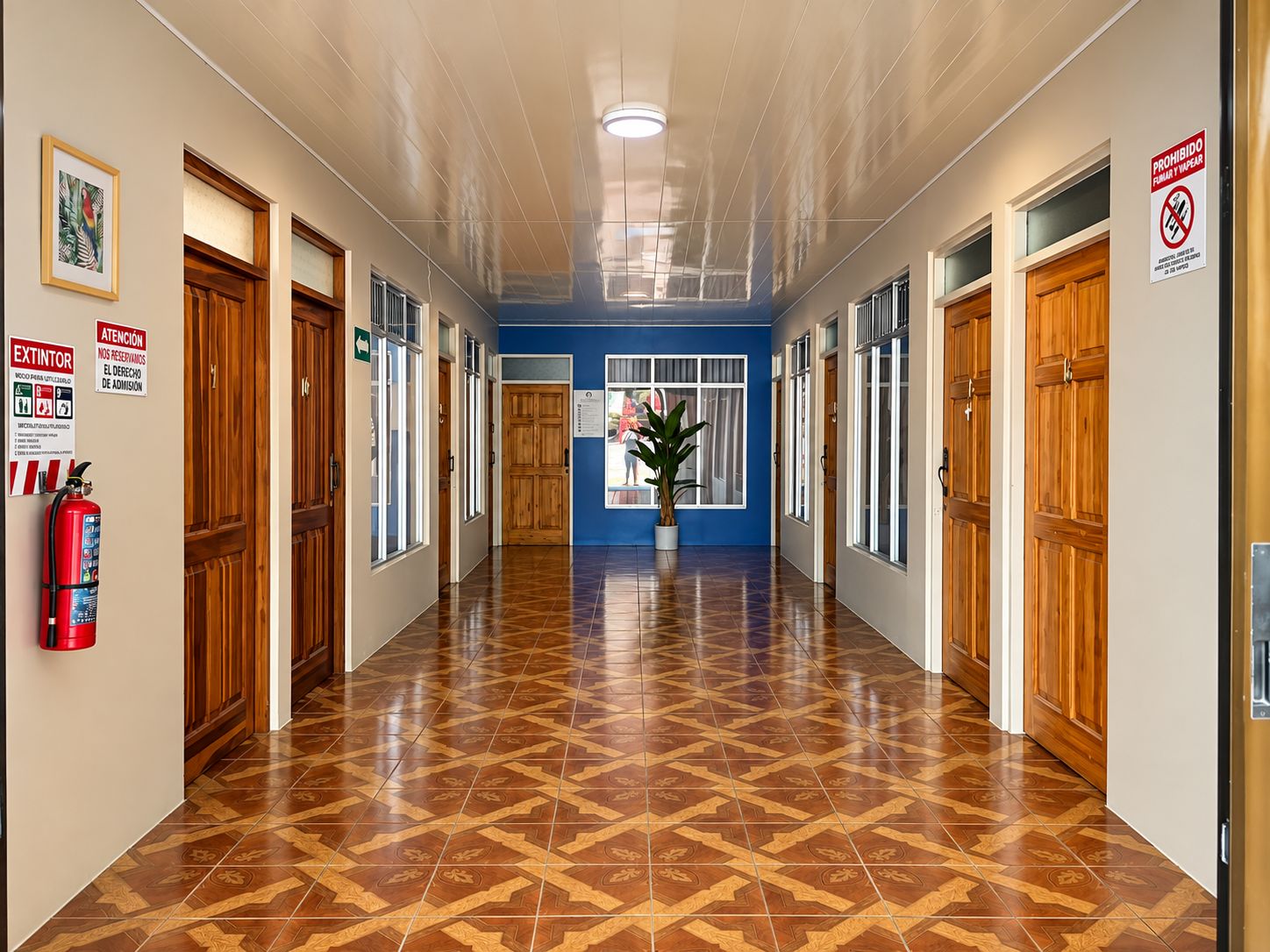 A hallway with wooden doors, a fire extinguisher, and a no-smoking sign.