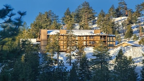 A lodge with a wooden exterior, multiple windows, and a snow-covered roof, surrounded by trees and a mountain backdrop. - 2BR Tahoe 3 Suite at WorldMark Lake Tahoe Near Heavenly Ski Resort (Stateline)