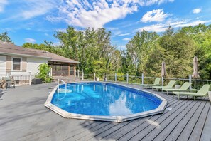 A swimming pool on a wooden deck with lounge chairs and a house in the background. - NEW - Maple Retreat - Hot Tub, Games, 8 min to NRG (Fayetteville)