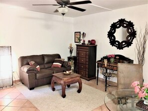 A living room with a sofa, coffee table, cabinet, and decorative items. - 1-Bedroom Apartment in Pelican Key with Shared Pool & Private Parking (Koolbaai)