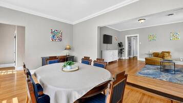 Comedor con una mesa redonda, sillas y un centro de mesa con plantas.