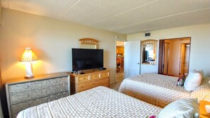 A hotel room with two beds, a television on a dresser, and a lamp. - Edgewater #506 - Peaceful 2-BR Families-Only Beachfront Sanctuary (South Padre Island)