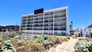A multi-story hotel with a modern design, featuring balconies on each floor. - Updated Beachfront Escape at Embassy #402 - Intimate 30-Unit Complex (South Padre Island)