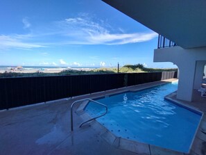 Ein Pool mit Blick auf Strand und Meer.