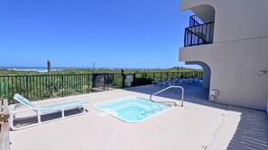 Ein Balkon mit Pool, Liegestühlen und Blick auf den Strand.