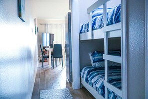 Une chambre avec des lits superposés, un bureau et une chaise.