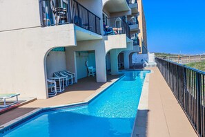 A pool area with lounge chairs and a clear view of the ocean. - Recently Remodeled Beachfront Escape at Florence 1 #307 - Corner Unit (South Padre Island)