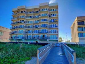 A multi-story hotel with balconies, a wooden walkway, and a clear sky. - Beachfront Studio at Florence 1 #608 - Incredible Gulf Views & Resort Comfort (South Padre Island)