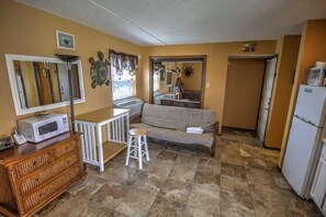 A compact living space with a kitchenette, a sofa, a small dining table, and a refrigerator. - Beachfront Studio at Florence 1 #608 - Incredible Gulf Views & Resort Comfort (South Padre Island)