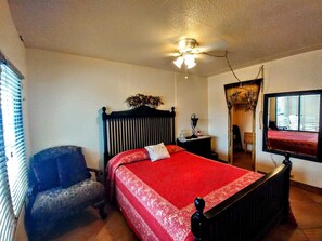 A bedroom with a bed, a chair, a nightstand, a ceiling fan, and a window with blinds. - Landfall Towers #34 - Stunning Bayfront Living with Private Boat Slip Access (South Padre Island)