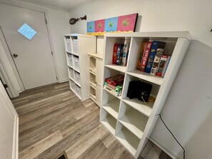 A room with a bookshelf, a door with a window, and a wall with a painting. - Pet-Friendly Ocean Lakes 4BR | Limo Golf Cart | Sleeps 9 (Myrtle Beach)
