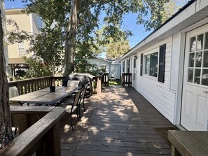A wooden deck with outdoor furniture, a barbecue grill, and a covered area with a table and chairs. - Pet-Friendly Ocean Lakes 4BR | Limo Golf Cart | Sleeps 9 (Myrtle Beach)