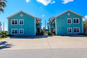 A two-story building with a flat roof, multiple windows, and a central entrance. - Sea Dreams #3 - Beautifully Upgraded Bayfront Retreat for an Unplugged Escape (South Padre Island)