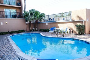 A swimming pool with a no diving sign, surrounded by lounge chairs and a small table. - Seagull #101 - Expansive Gulf Views in a Private Beachfront Sanctuary (South Padre Island)