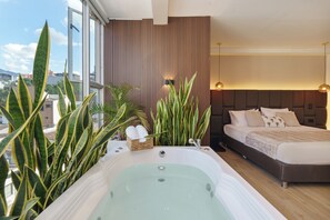 Un dormitorio moderno con una cama grande, una bañera y vistas a la ciudad.