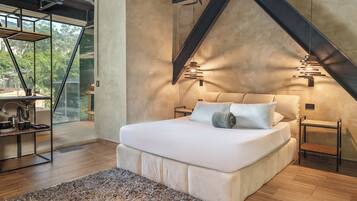 Ein modernes Schlafzimmer mit einem großen Bett, Holzböden und Blick durch eine Glastür.