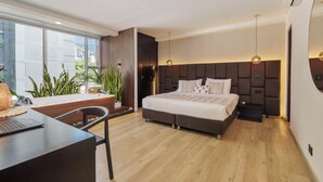 Quarto moderno com uma cama grande, uma escrivaninha e vista para a cidade.