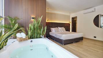 Ein modernes Schlafzimmer mit einem großen Bett, einer integrierten Badewanne und einer Holzwandverkleidung.