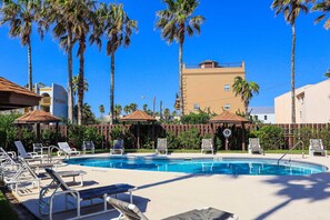 A swimming pool with lounge chairs and palm trees. - Coastal 2-BR Pet-Friendly Haven at Surfside 1 #210 - 2 Minutes to the Sand (South Padre Island)