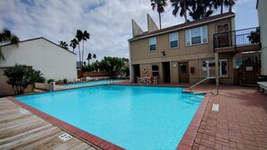 A swimming pool with a wooden deck and a lifeguard stand. - Sandcastle 201B - Affordable Bayside Efficiency Perfect for Small Families (South Padre Island)