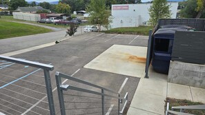 Ein Parkplatz mit einem weißen Gebäude im Hintergrund, auf dem '9th Street Garage' steht.