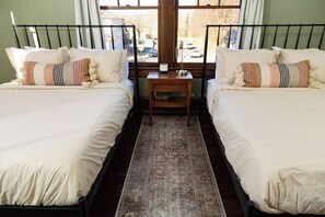 A room with two beds, a nightstand, and a window with a view of the outside. - Stay Roanoke | 4BR Near Greenway, Dining, Drinks (Roanoke)