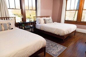 A bedroom with two beds, a nightstand, and a window with a view. - Stay Roanoke | Walkable 2BR Near Greenway (Roanoke)