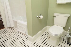 Ein Badezimmer mit Toilette, Dusche und einem gemusterten Boden.