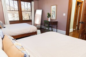Ein Schlafzimmer mit zwei Betten, einem Schreibtisch und einem Stuhl.